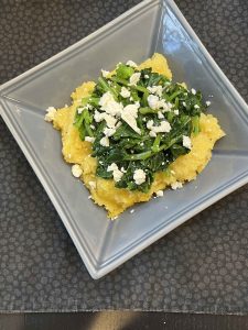 Bowl of polenta with broccoli raab and feta cheese